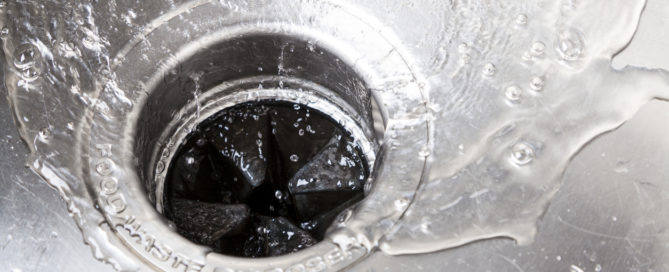 Closeup of garbage disposal with water running down it