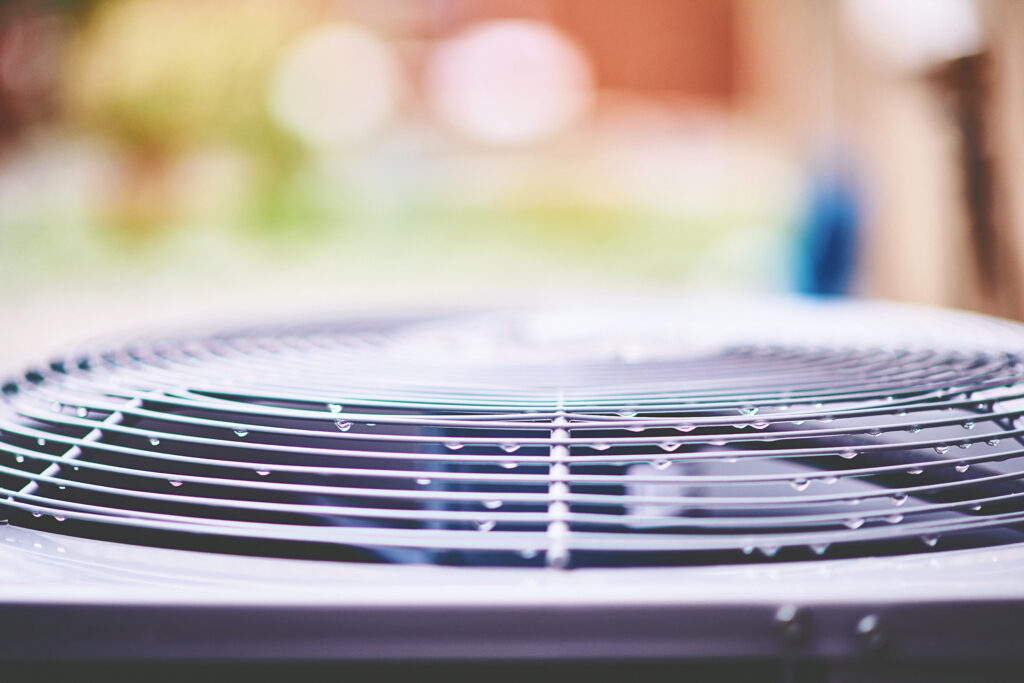 Close-up of an AC unit with beads of moisture on it