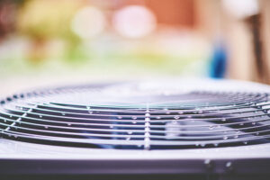 Close-up of an AC unit with beads of moisture on it