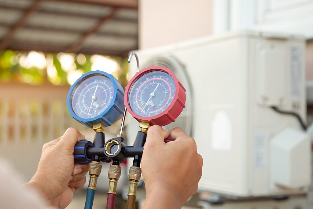 technician using pressure gauge heat pump